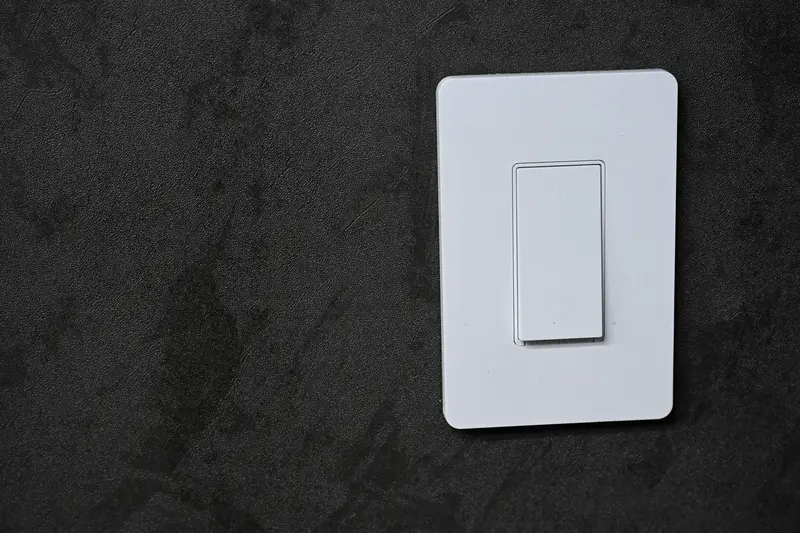 A smart light switch being wired into a wall box during an install
